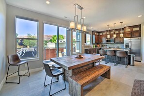 Una cocina moderna con una isla grande, taburetes de bar y vistas al exterior.