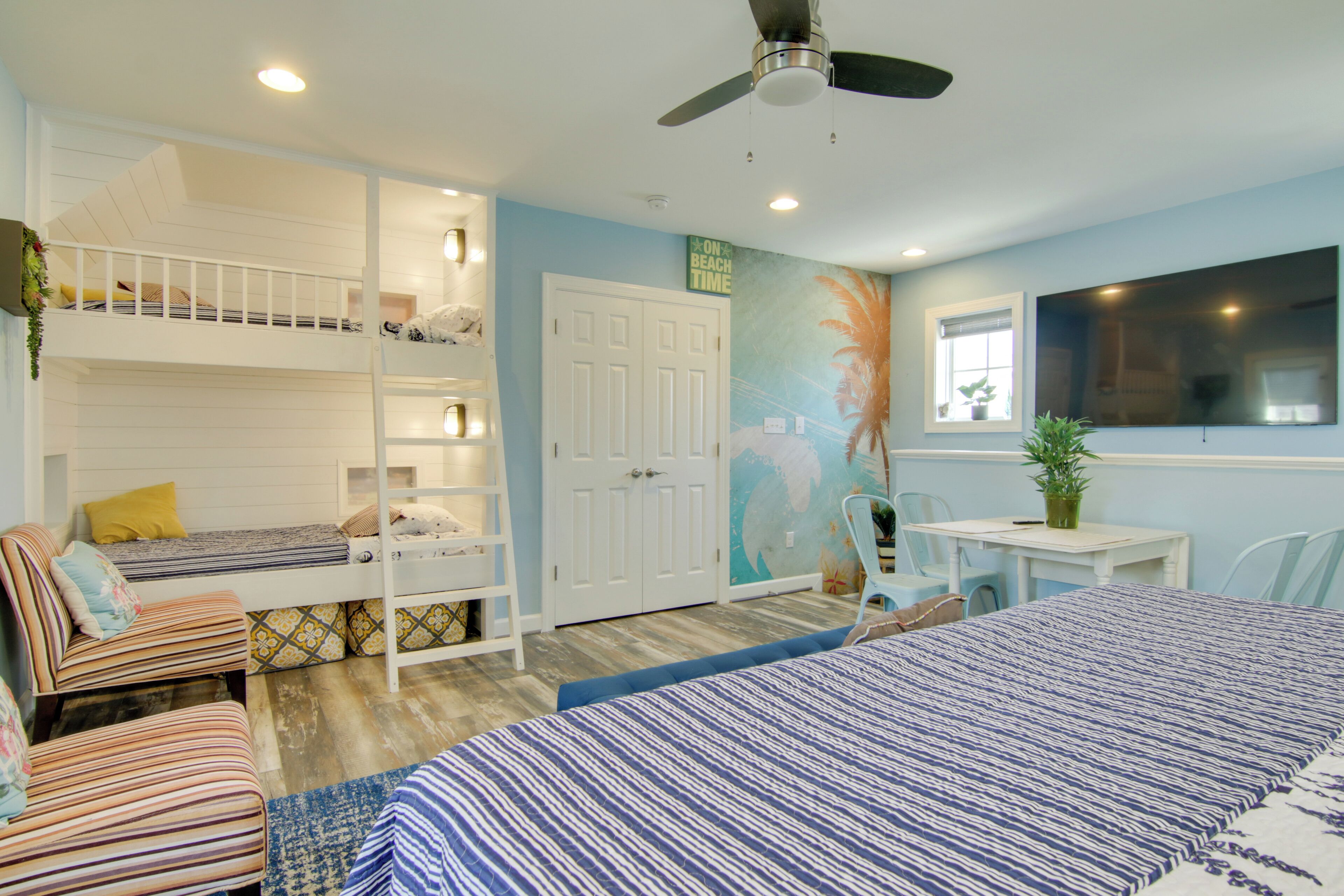 A bedroom with bunk beds, a desk, and a chair.