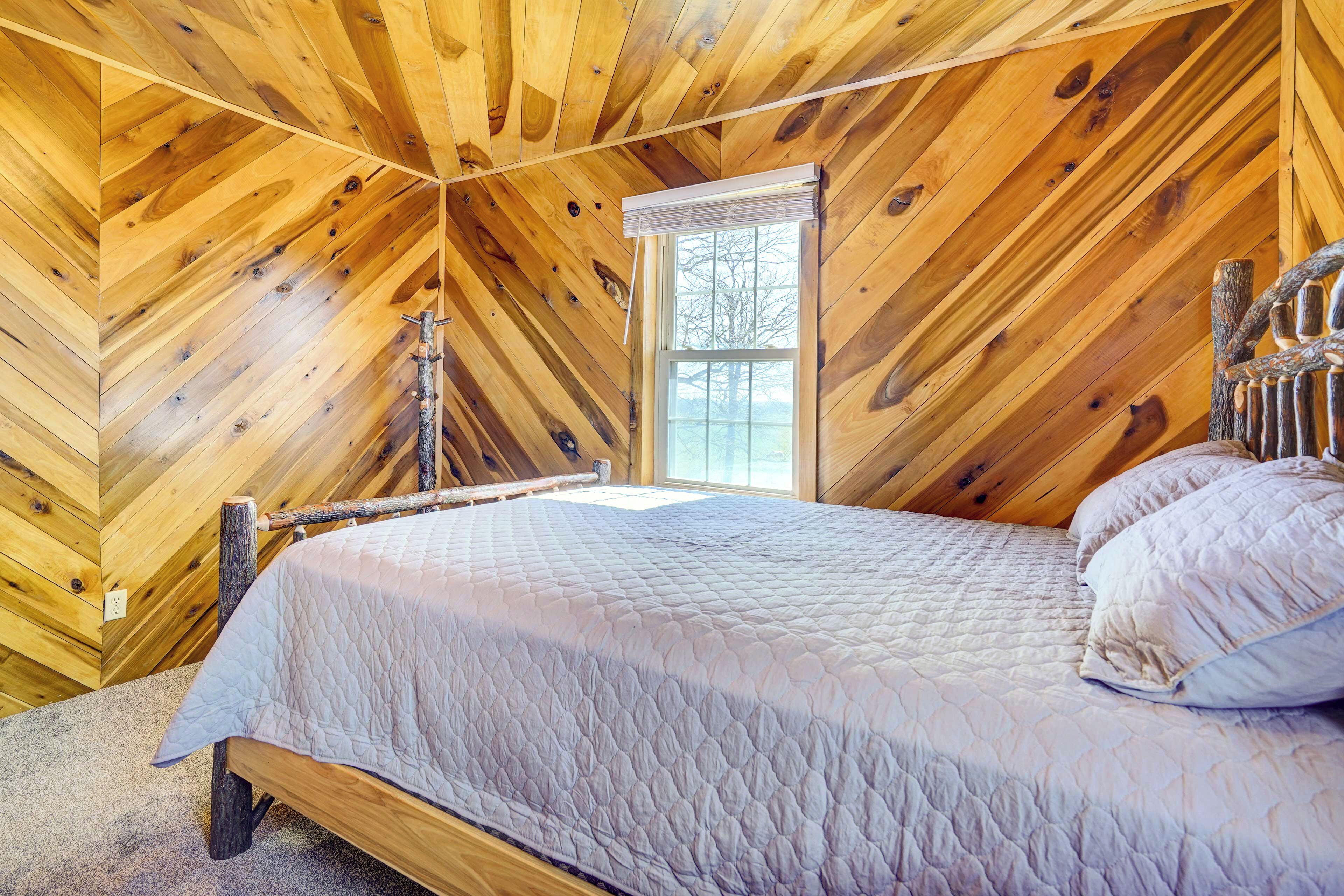 A wooden-paneled room with a bed, a window, and a wooden headboard.