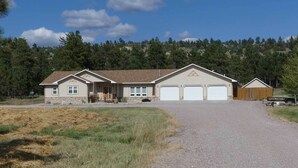 A two-story house with a garage, a front porch, and a fenced yard.