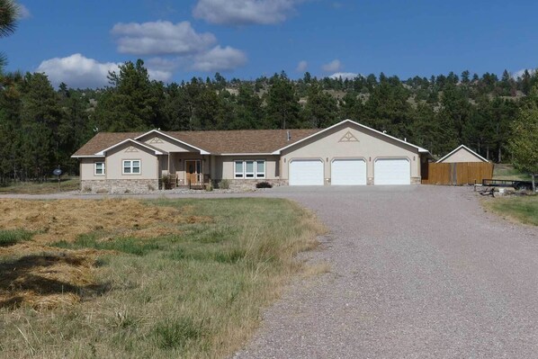 A two-story house with a garage, a front porch, and a fenced yard.