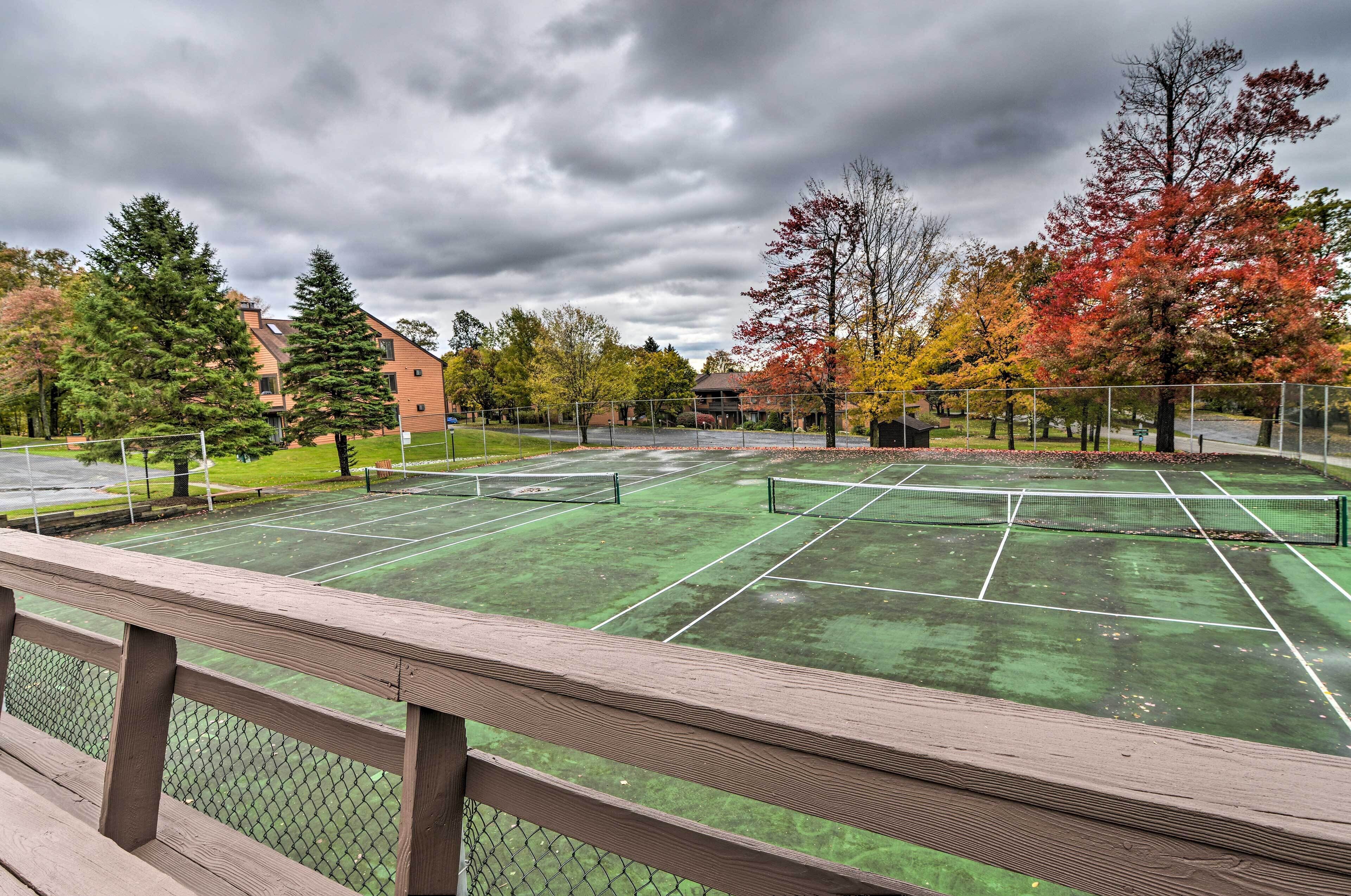 A tennis court with a wooden fence in the foreground.