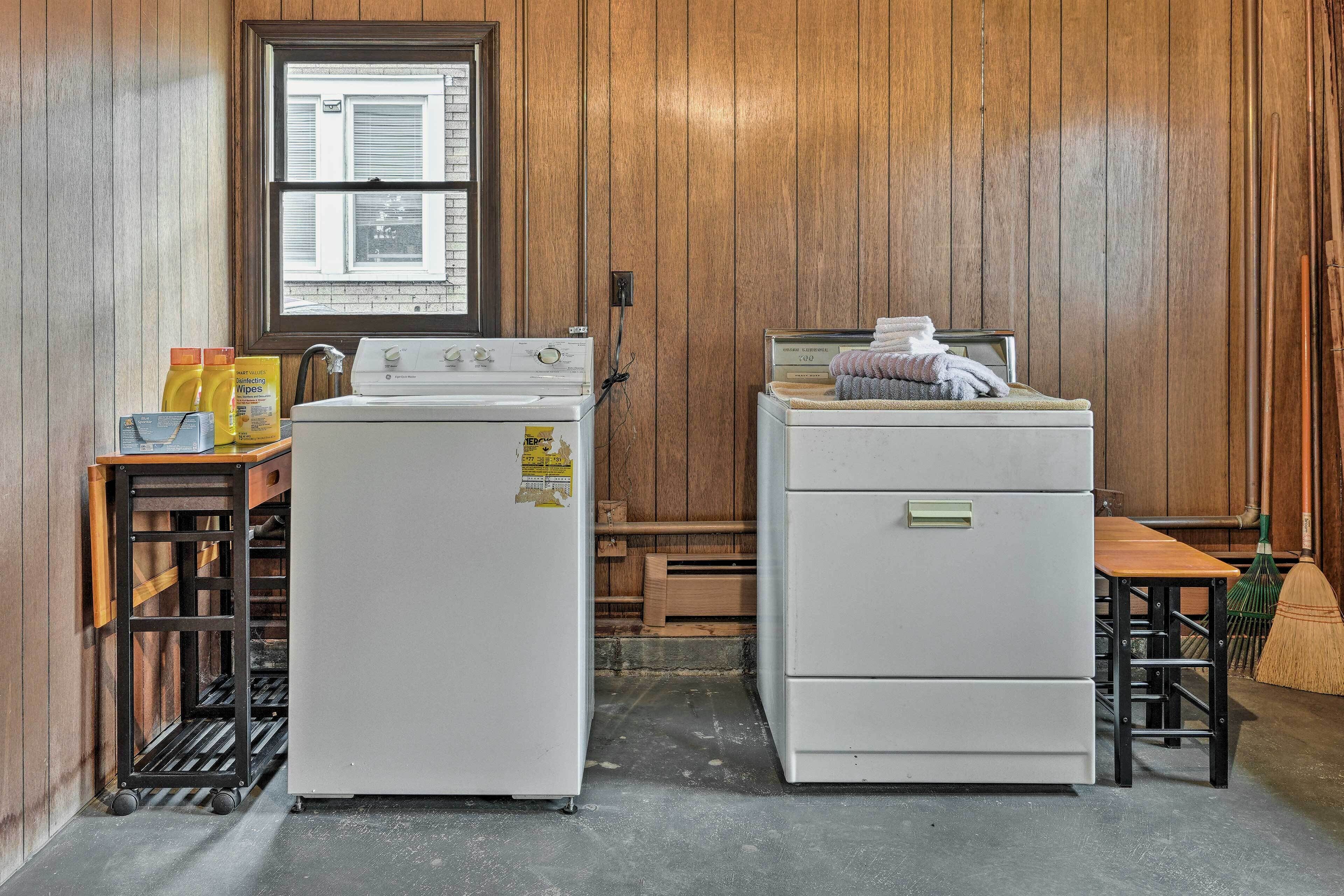 A laundry room with a washing machine, dryer, and ironing station.