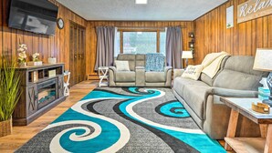 A cozy living room with a large TV, a fireplace, and a comfortable sofa.