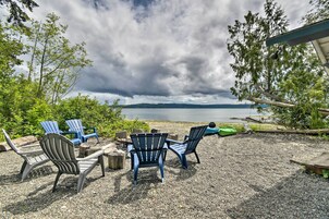 Un patio de grava con sillas Adirondack y vistas al lago.