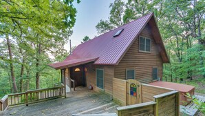 A cabin with a wooden deck and a metal roof, surrounded by trees. - Peaceful Russellville Cabin Close to Lakes! (Russellville)