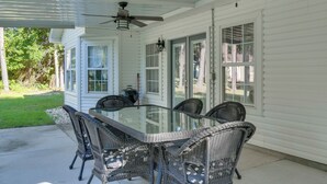 A covered patio with a glass-top table and wicker chairs, a ceiling fan, and a view of the backyard. - Peaceful Fairhope Cottage w/ Covered Patio! (Fairhope)