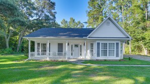 A single-story house with a front porch, a covered entryway, and a small front yard. - Peaceful Fairhope Cottage w/ Covered Patio! (Fairhope)