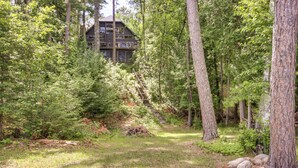 A forested area with a cabin and a staircase leading up to it. - Thunder Lake Escape + Boat Dock! (Remer)