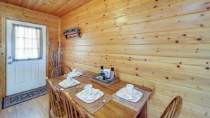 A wooden interior with a dining table set for four, a door, and a window with curtains. - Secluded Lenoir Cabin: 4 Mi to Dtwn Blowing Rock (Lenoir)