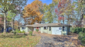 A two-story house with a front yard covered in fallen leaves.