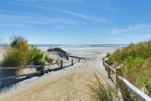 A sandy beach path with wooden railings and vegetation on either side. - Spacious Wildwood Townhome w/ Covered Balcony (North Wildwood)