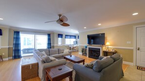 A living room with a sofa set, a coffee table, a fireplace, and a television.