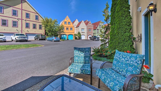 A row of colorful houses with a street in front, a bench, and a tall tree. - Unique Townhouse in Bavarian-style Neighborhood! (Adamstown)
