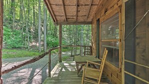 A wooden cabin with a porch, a table, and a chair. - Pisgah Forest 'the Oak' Cabin w/ Deck by Creek (Barnardsville)