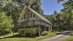 A two-story house with a stone chimney, a balcony, and a gravel driveway. - Spacious Home w/ Deck, Grill & Delaware River View (Callicoon)