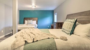 A bedroom with two beds, a teal accent wall, and a wooden headboard. - Spacious & Private Home w/ Lazy Mountain View (Palmer)