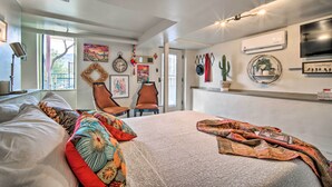 Een slaapkamer met een groot bed, een stoel, een wandklok en een televisie.