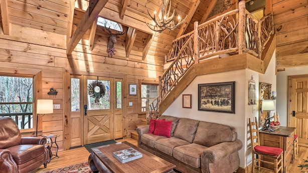 A rustic wooden interior with a leather sofa, a coffee table, and a staircase with a wooden railing. - Private Sapphire Valley Resort Cabin w/ Mtn Views! (Sapphire)