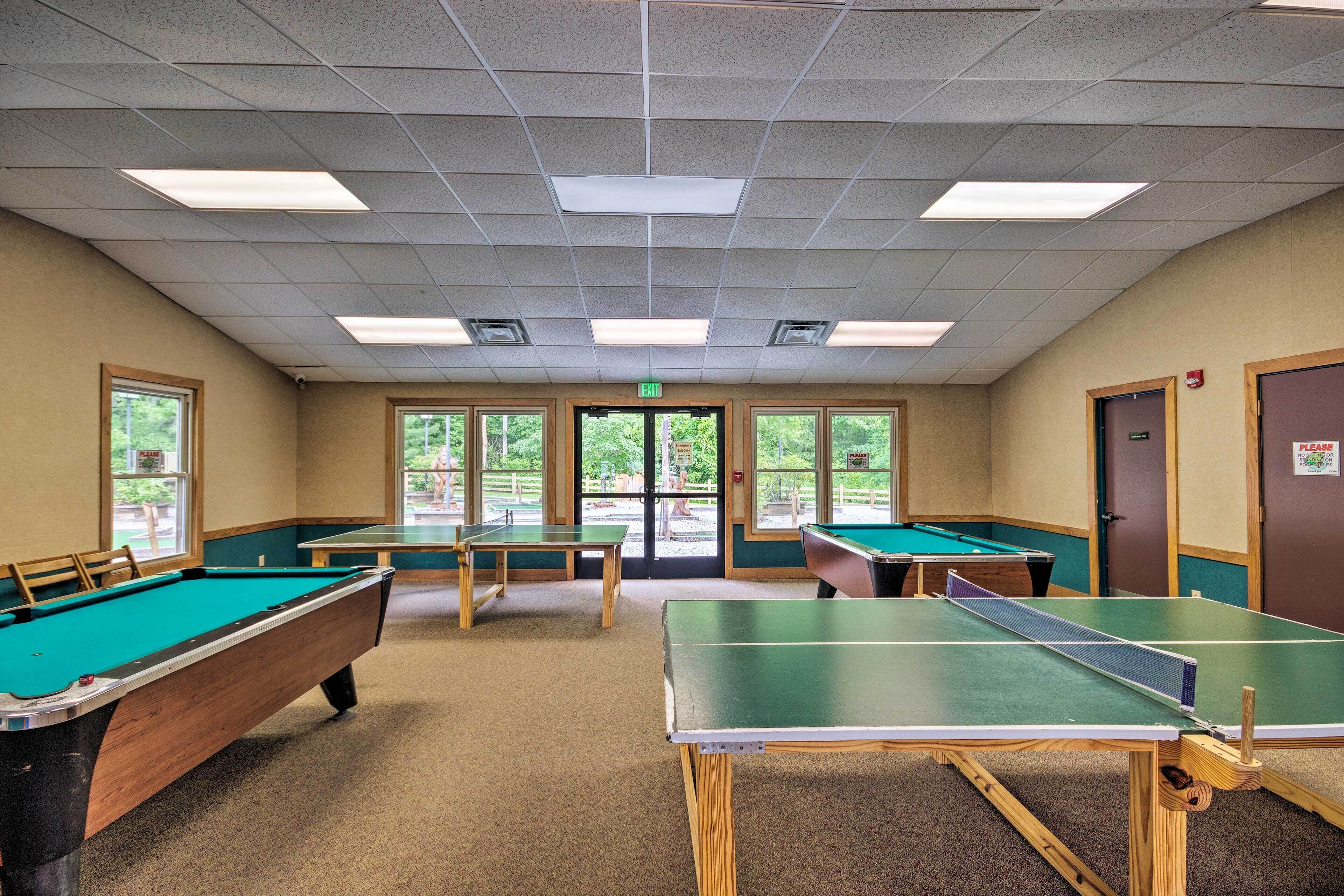 Zona de billar con varias mesas y una mesa de ping pong.