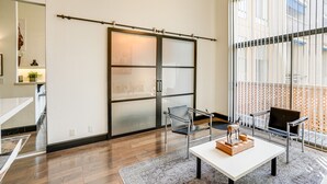 A modern interior with a sliding glass door, a sofa, a coffee table, and a view of the outside.