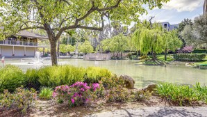 A serene park with a pond, lush greenery, and a gazebo.