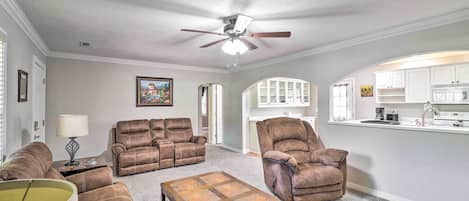 A living room with a ceiling fan, a sofa, a recliner, and a coffee table.