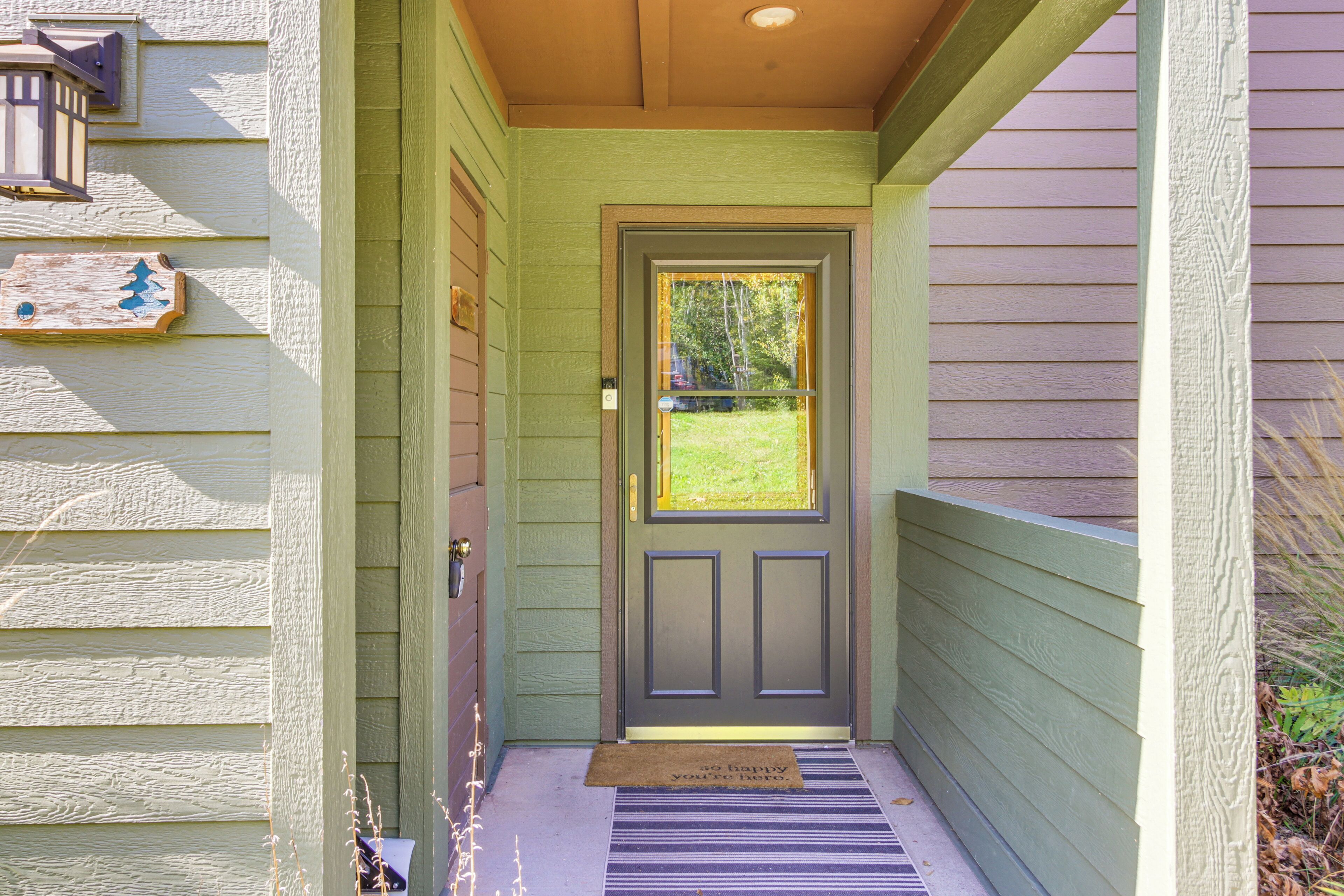 A front door with a doormat, a mailbox, and a small window above the door.