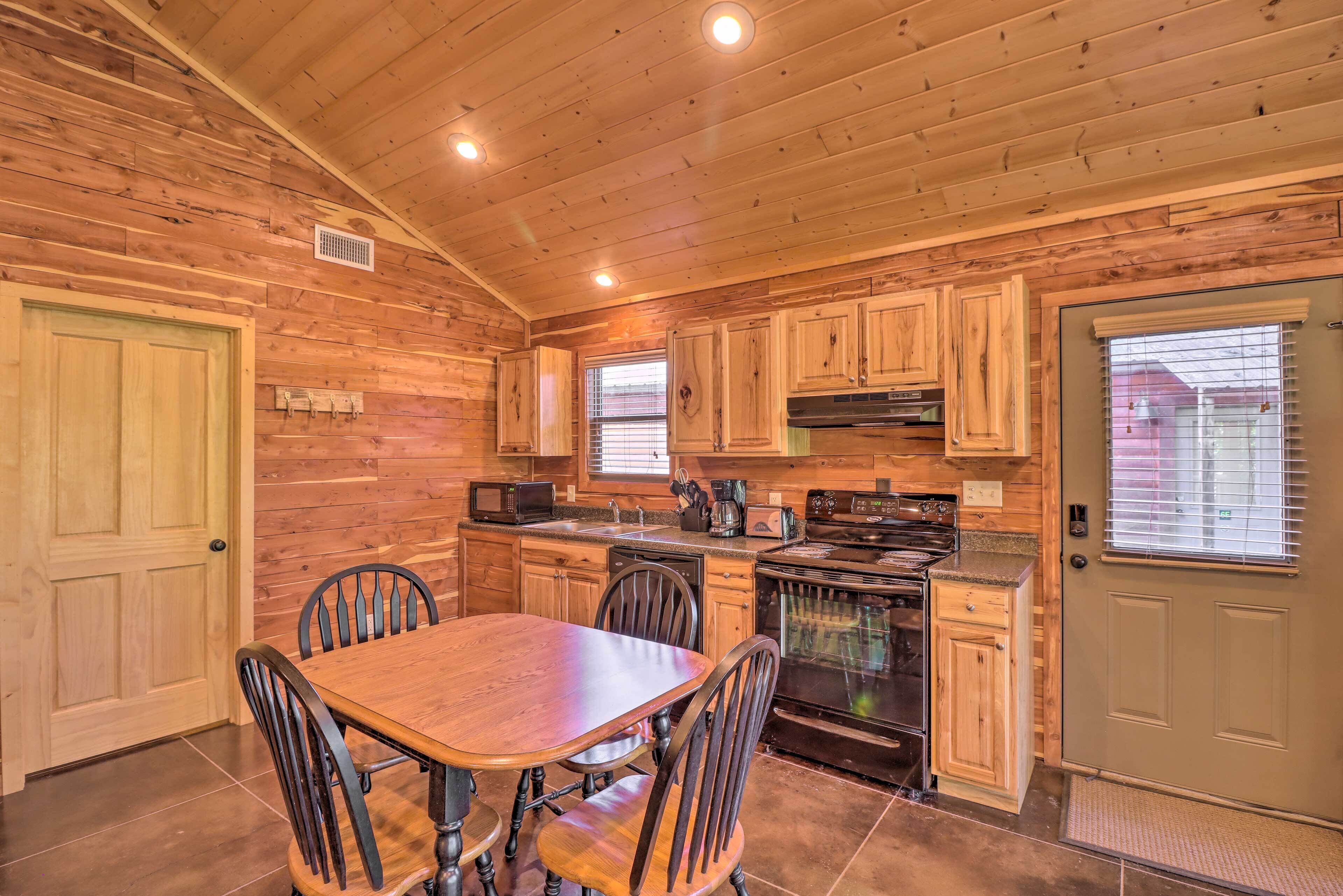 A wooden interior with a dining table and chairs, a stove, and cabinets.
