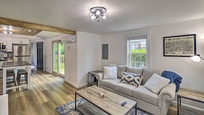 A modern living room with a sofa, coffee table, and a kitchen area in the background. - Updated Bristol Retreat ~ 2 Miles to Downtown! (Bristol)