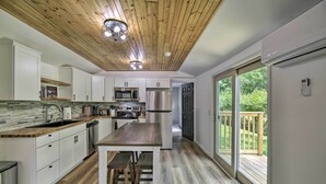 A modern kitchen with white cabinets, a wooden ceiling, and a large island with stools. - Updated Bristol Retreat ~ 2 Miles to Downtown! (Bristol)