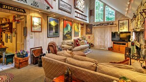 A cozy living room with a large couch, a television, and various decorations including framed pictures and a fireplace. - West Dover Vacation Rental w/ Hot Tub Near Mt Snow (West Dover)