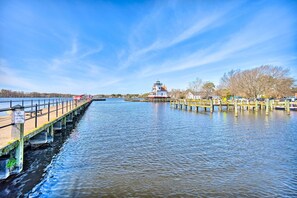 A waterfront view with a pier extending into the water, a lighthouse in the distance, and a clear blue sky. - Edenton Vacation Rental w/ Patio: Walk Downtown (Edenton)