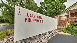 Placa para 'Lake Area Properties', com base de pedra e poste de madeira.