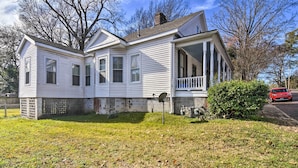 A two-story house with a front porch, a satellite dish, and a small front yard. - Stylish Vicksburg Apt w/ Porch - 2 Mi to Casino! (Vicksburg)