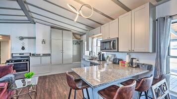 A modern kitchen with granite countertops, stainless steel appliances, and a central island with bar stools.