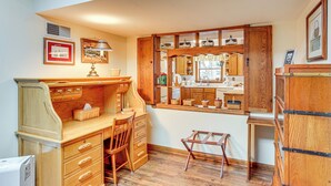 A compact kitchen with wooden cabinets, a built-in window, and a small dining area.