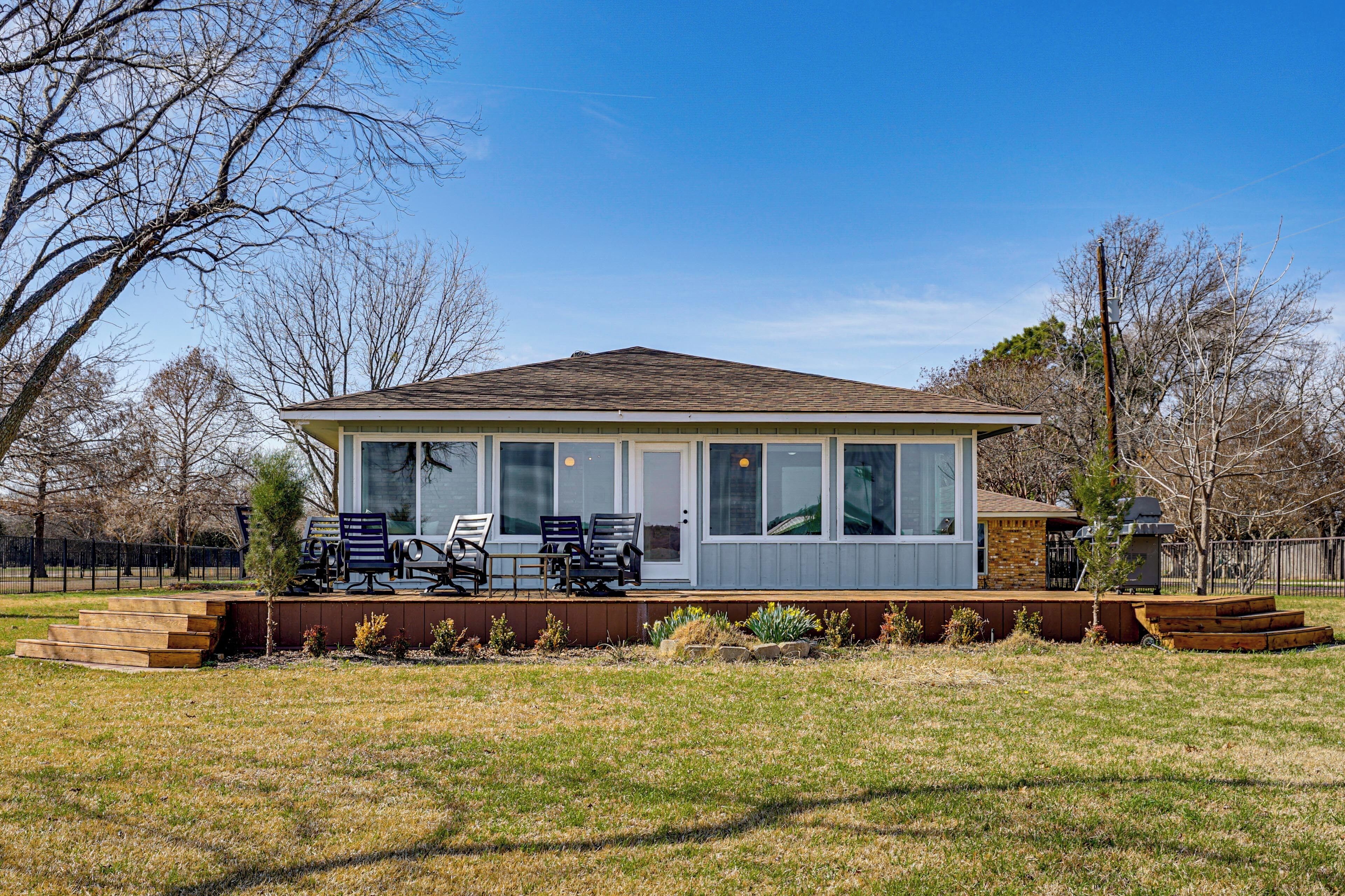 A house with a covered porch, a small deck, and a front yard.