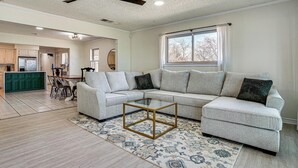 A spacious living room with a sectional sofa, a glass coffee table, and a large window. - Private Beach & Dock: Home on Eagle Mountain Lake (Azle)