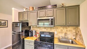 A kitchen with a refrigerator, microwave, stove, sink, and cabinets. - Stylish Woodville Cabin: Fishing Dock Access! (Woodville)