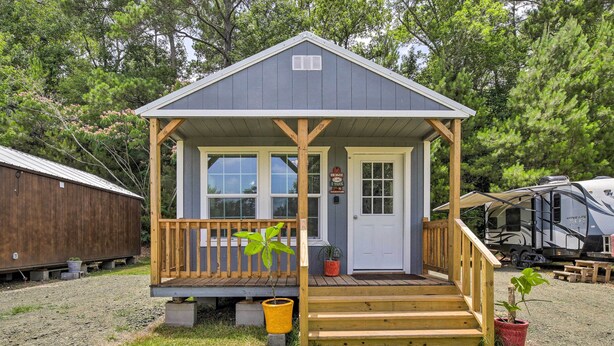 A small, single-story building with a porch, a door, and a window. - Stylish Woodville Cabin: Fishing Dock Access! (Woodville)