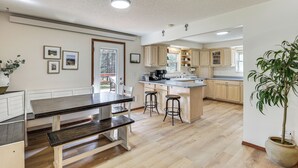 Une cuisine spacieuse avec des meubles en bois, un îlot central et un coin repas équipé d’une banquette.