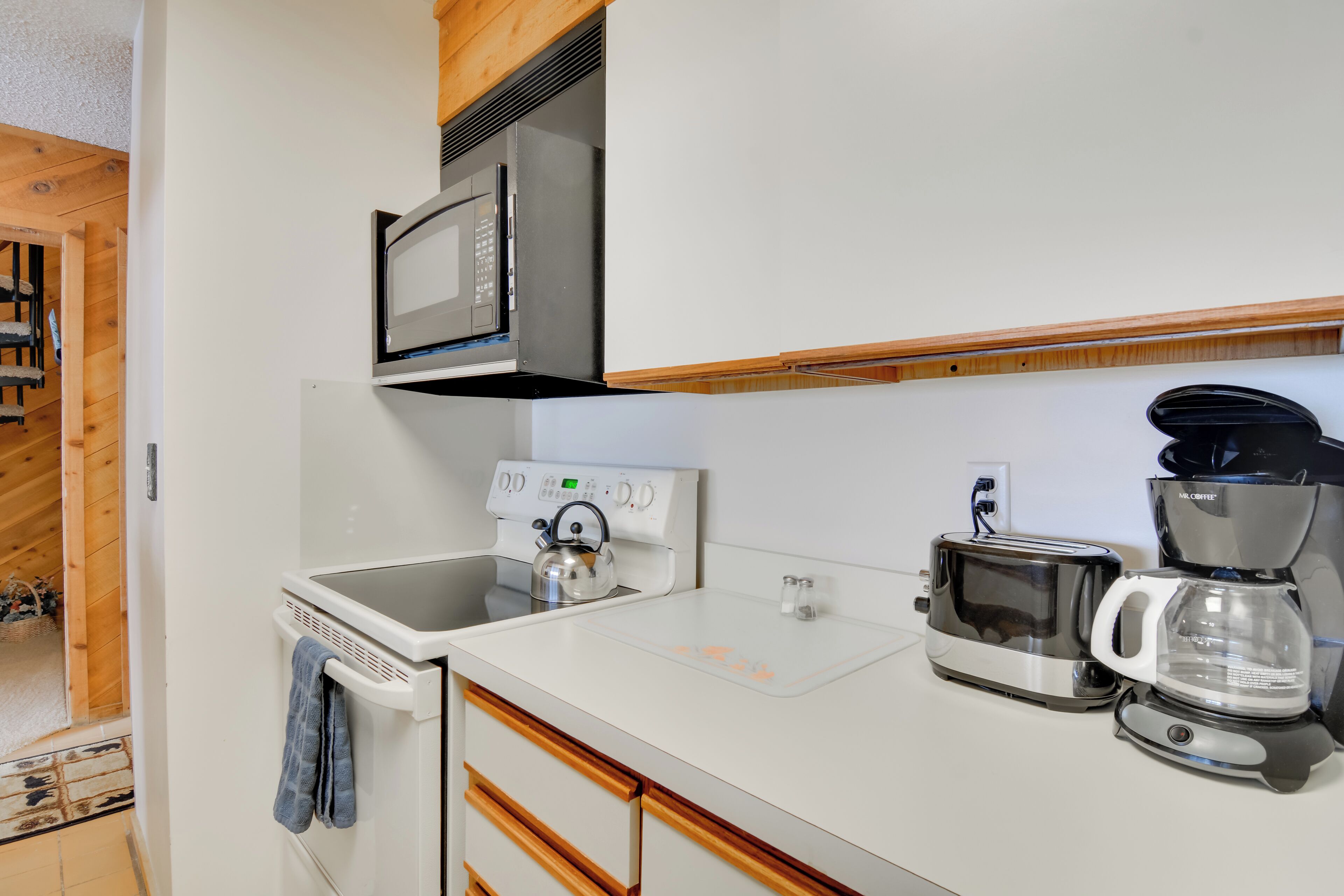 A modern kitchen with a microwave, coffee maker, and toaster.