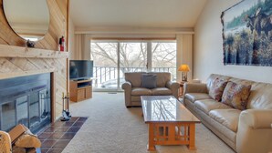 A living room with a fireplace, a sofa, a coffee table, and a television.