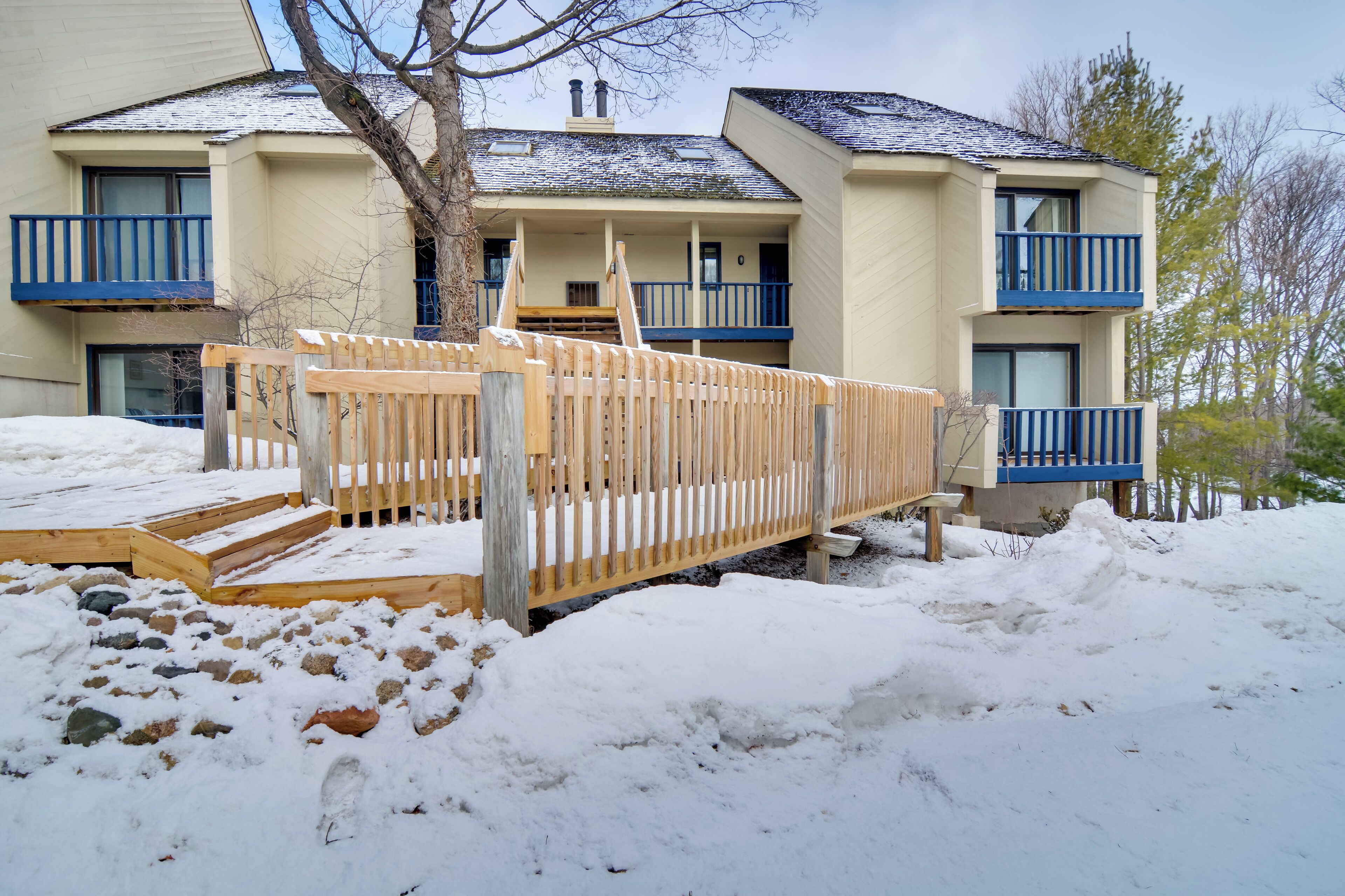 A two-story building with a wooden deck and a blue railing.