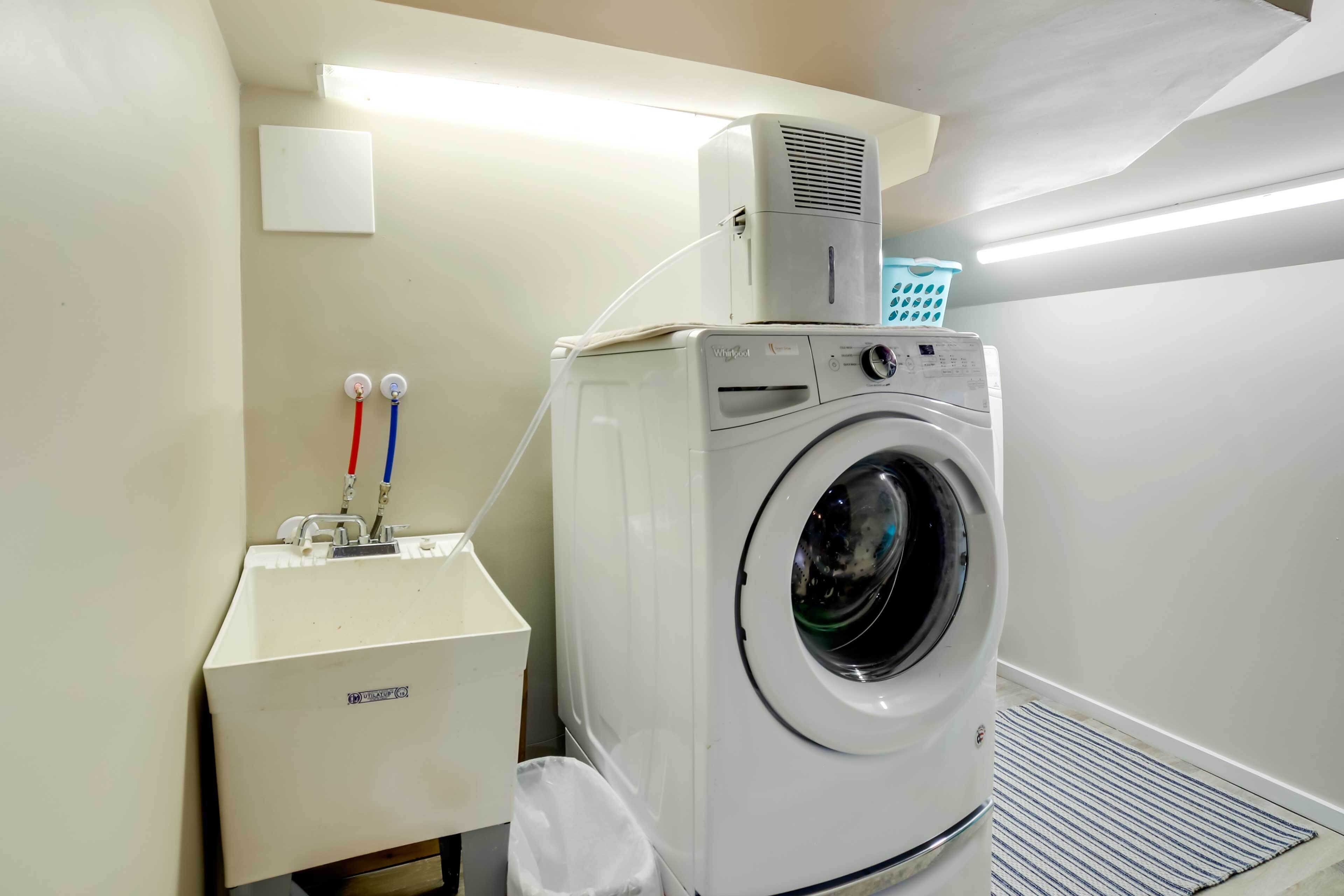 A laundry area with a washing machine, a dryer, and a utility cabinet.
