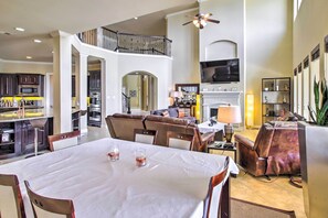A spacious living area with a high ceiling, a fireplace, and a television. - Waterfront Home w/ Boat Dock on Lake Houston! (Houston)