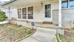 A residential house with a covered porch, a front door, and a small garden area. - Ann Arbor Getaway w/ Yard: Near Umich & Stadium (Ann Arbor)