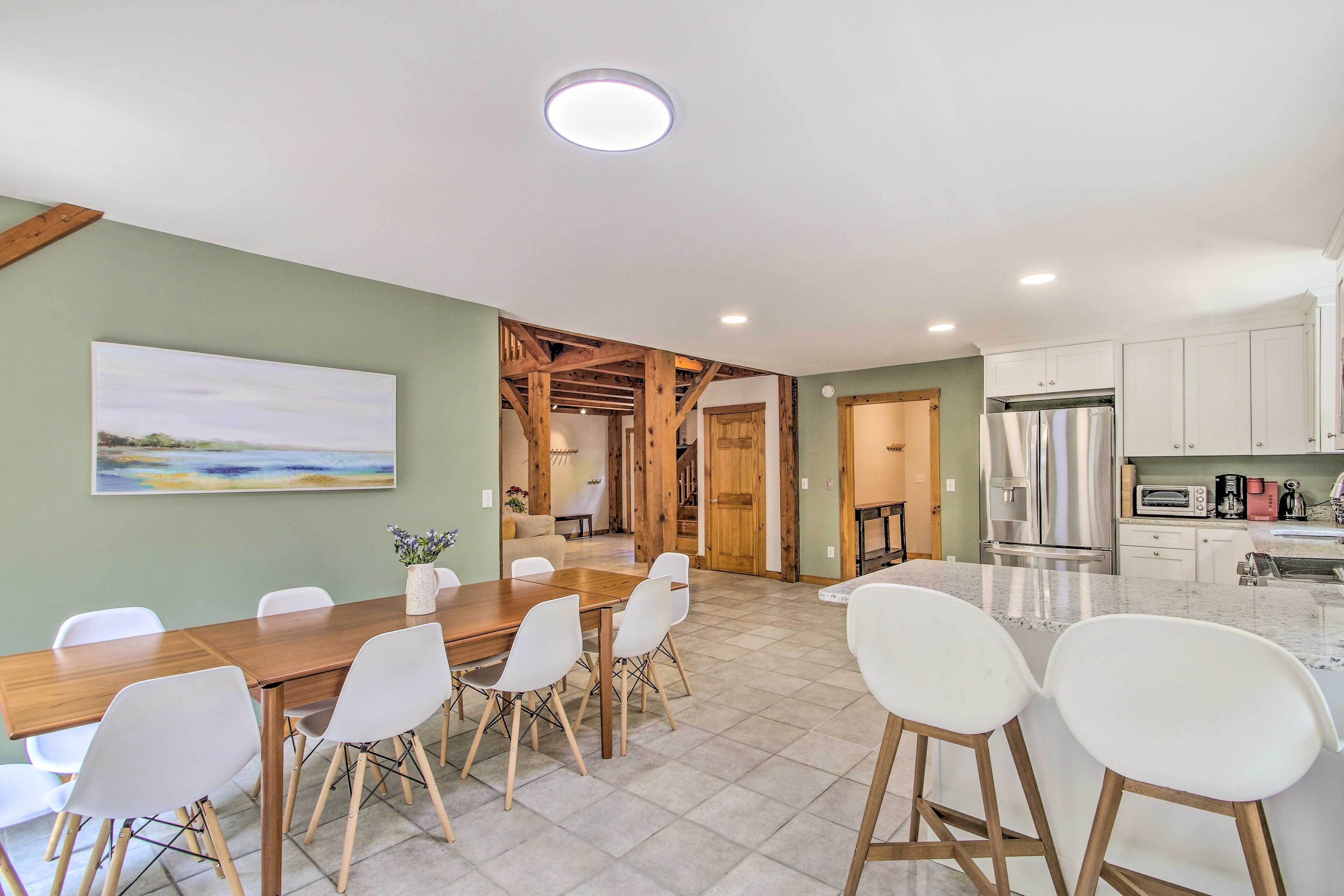 A modern kitchen with white cabinets, stainless steel appliances, and a marble countertop.