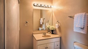 A bathroom with a sink, mirror, and towel rack. - Inviting Lubbock Home > 1 Mi to Downtown (Lubbock)